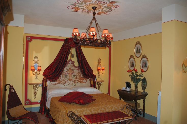 Camera con letti a baldacchino e decorazioni sobrie, con un'illuminazione calda e accogliente.