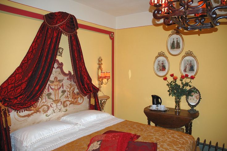 Camera semplice con letto a baldacchino, decorazioni sobrie e un'atmosfera tranquilla.