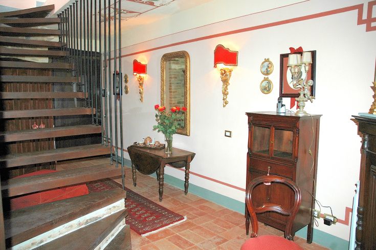 Spazio confortevole con scala di legno e dettagli tradizionali, perfetto per momenti di tranquillità.