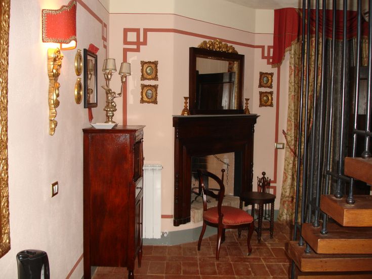 Angolo di una villa con camino, arredato con elementi classici e dettagli curati.