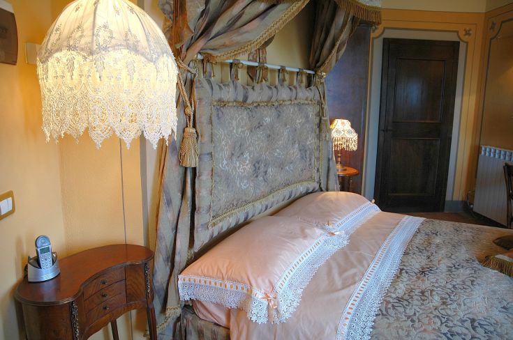 Interno di una camera con letti a baldacchino e decorazioni semplici.