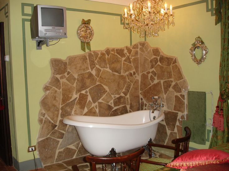 Un bagno raffinato con vasca autonoma, dettagli in pietra e un'atmosfera accogliente.