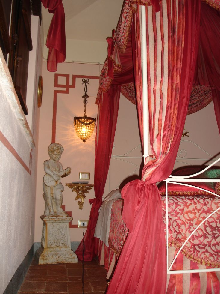 Camera con letti a baldacchino e decorazioni sobrie, ambiente accogliente e curato.