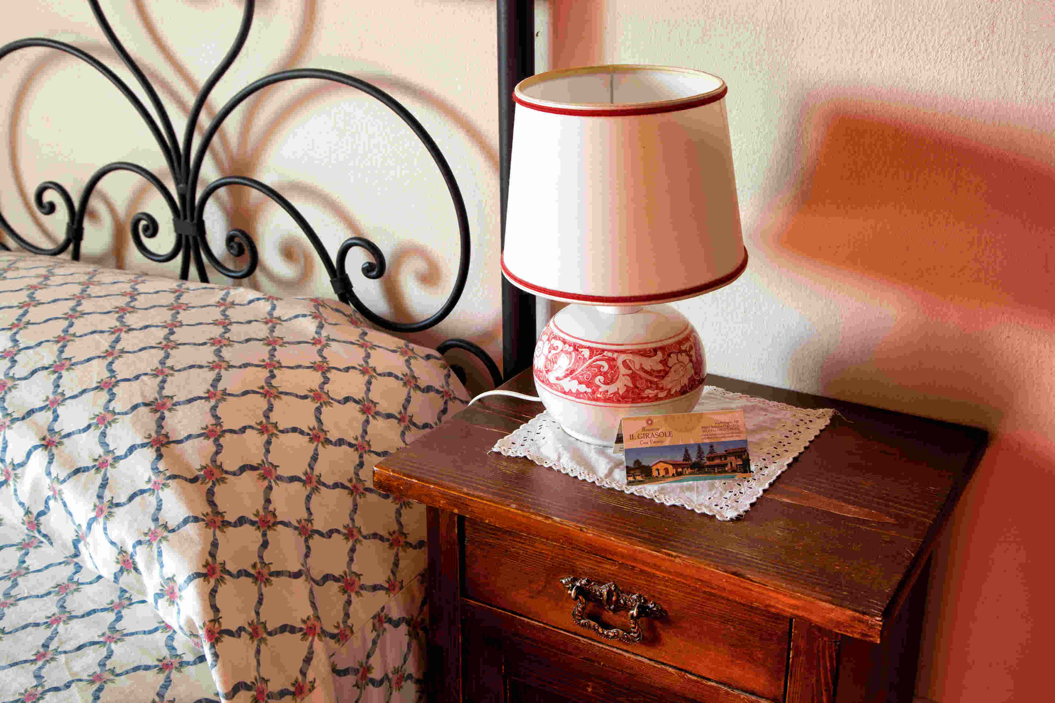 Un angolo confortevole con lampada e comodino in un ambiente semplice e rustico.