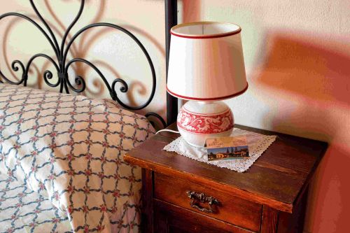 Eine gemütliche Ecke mit einer Lampe und einem Nachttisch in einer einfachen, rustikalen Umgebung.