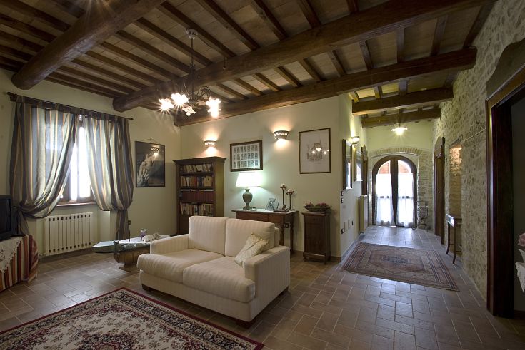 Un salotto tipico umbro, caratterizzato da un soffitto in legno e arredi sobrii.