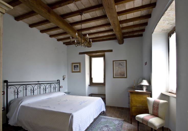 Spazio accogliente con soffitto in legno e mobili semplici, situato in un contesto tranquillo dell'Umbria.