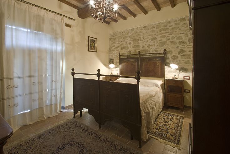 Una stanza confortevole con mobili in legno e pareti in pietra, perfetta per un soggiorno tranquillo.