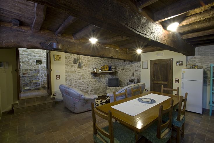 Comodo soggiorno con travi in legno e arredamento tipico della zona, perfetto per momenti di relax.