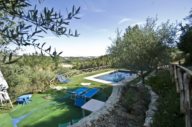 Casale circondato da verde con piscina e aree per il relax, perfetto per una soggiorno in Umbria.