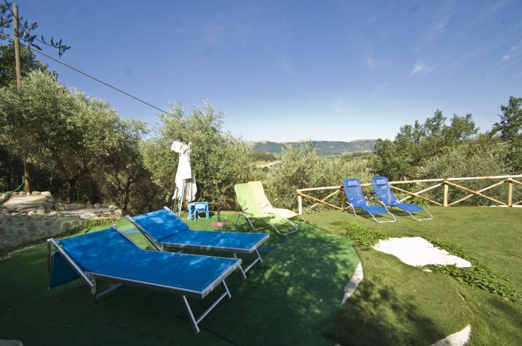 Un'area tranquilla nel verde con sdraio, ideale per il relax all'aperto.