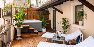 A terrace with green plants, sun loungers, and a hot tub, perfect for relaxing moments.