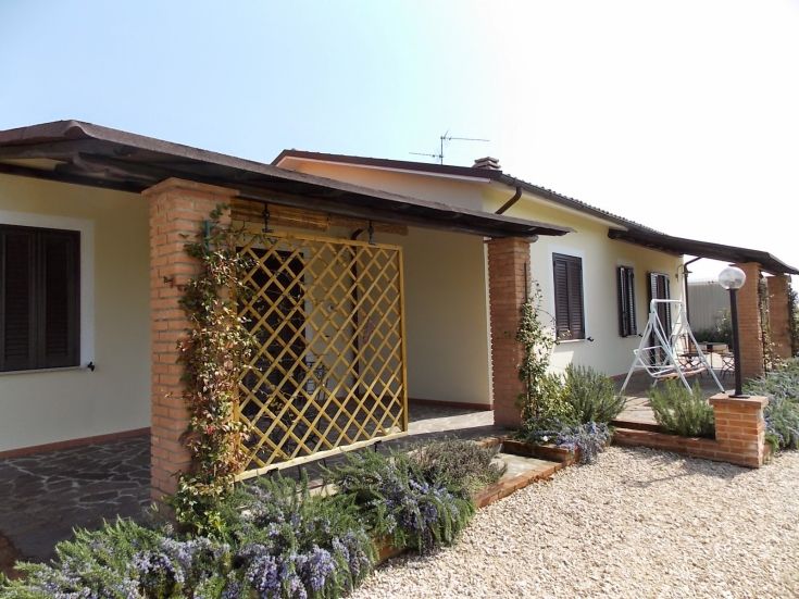 Eine ländliche Struktur mit Garten und Veranda, ideal für einen Rückzugsort auf dem Land.