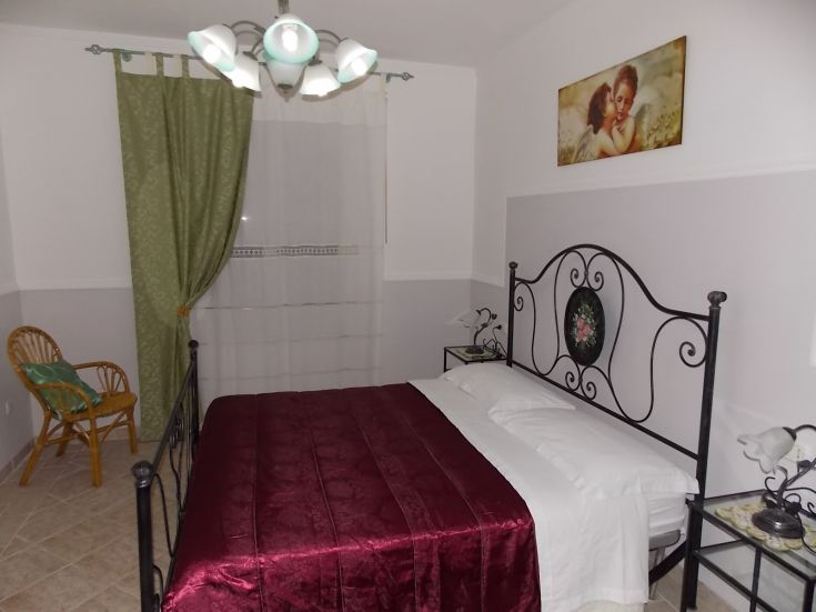 Gemütliches Zimmer mit einem Doppelbett, einfachen Dekorationen und einer Leseecke. Perfekt für einen ruhigen Aufenthalt.