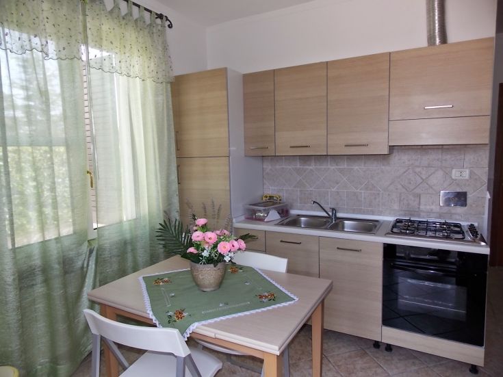 Geräumige und helle moderne Küche mit zeitgemäßem Layout und einem Blütenmittelpunkt, ideal für Entspannungsmomente.