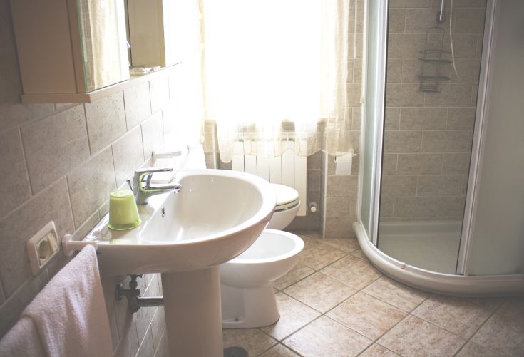 Geräumiges und gut beleuchtetes modernes Badezimmer mit einem modernen Waschbecken und einer Duschkabine, perfekt zum Entspannen.