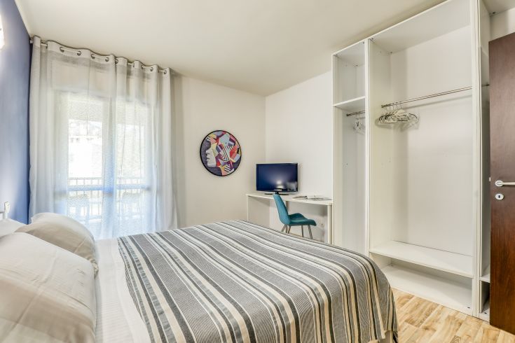 Camera semplice e confortevole con mobili funzionali, adatta per un soggiorno tranquillo.