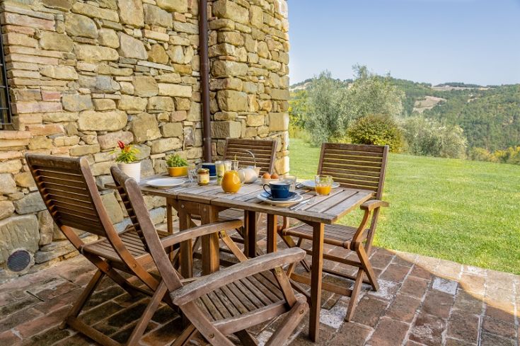 Eine gemütliche Holzveranda, perfekt für Frühstück im Freien, mit Blick auf die umliegende Landschaft.