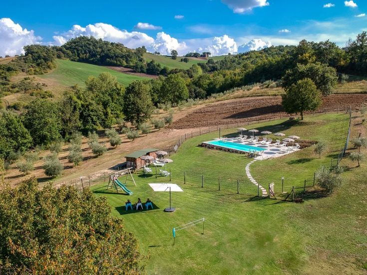 Eine Bauernhof in einer natürlichen Umgebung, mit Pool und großen Grünflächen ideal für Familien und Gruppen.