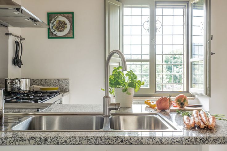 Geräumige und helle Küche mit Blick auf einen großen Garten. Holzmöbel und natürliche Details schaffen eine angenehme Atmosphäre.