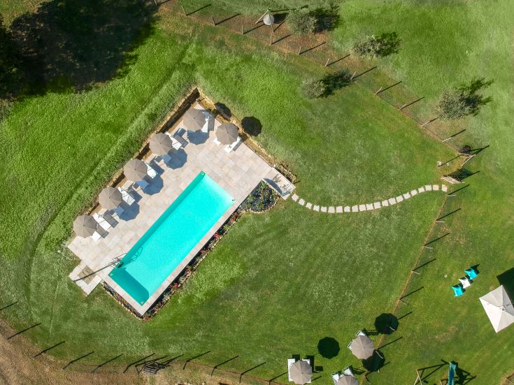 Ein Entspannungsbereich mit einem Pool, umgeben von Grün, perfekt, um die umliegende Natur zu genießen.