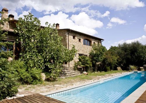 Una villa con piscina immersa in un ampio giardino e circondata da vegetazione tipica della zona.