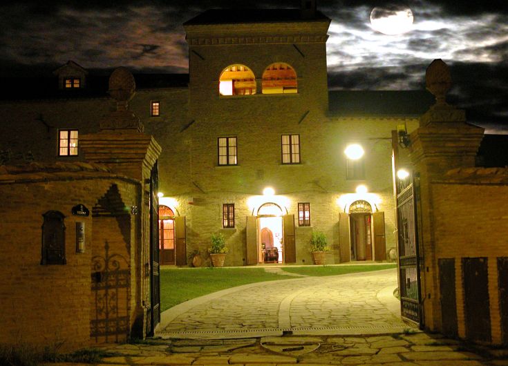Un paisible farmhouse de campagne avec une porte d'entrée historique, illuminé par la lumière de la lune.