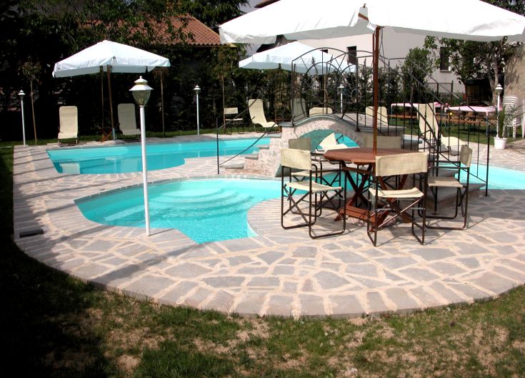 Zone de piscine équipée de parasols et de chaises longues pour la détente.