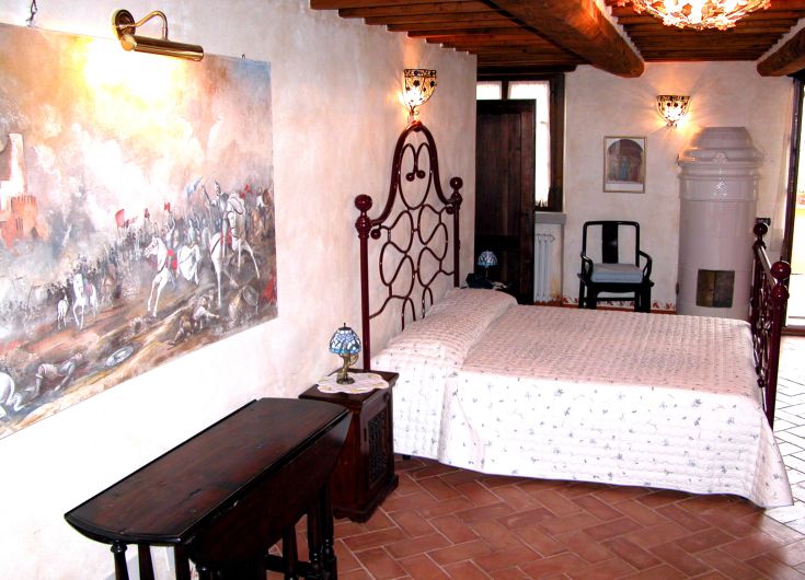 Une chambre accueillante avec un lit double et des meubles rustiques, idéale pour des moments de détente.