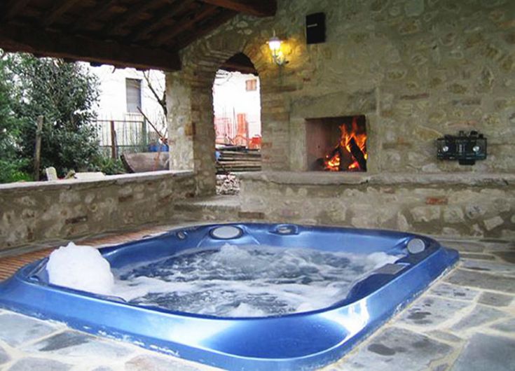 Espace bien-être avec jacuzzi et chemine, idéal pour des moments de détente dans un cadre accueillant.
