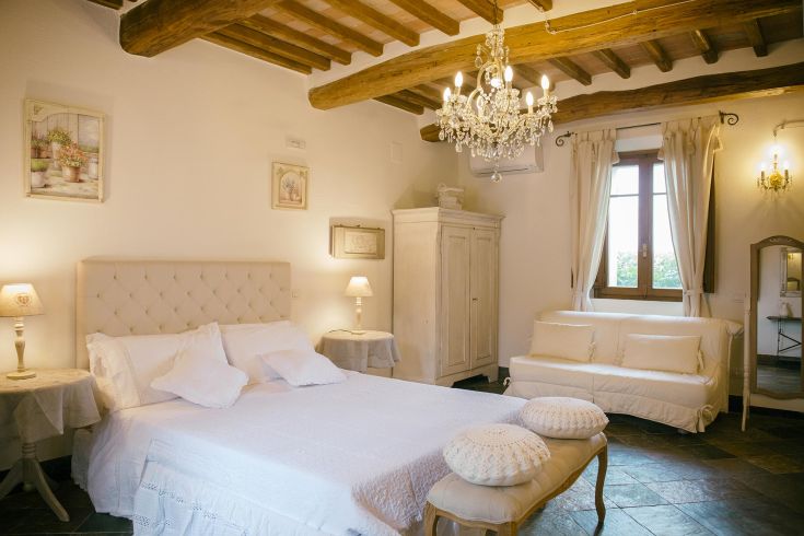 Simple room with a double bed and functional furnishings, surrounded by greenery. Ideal for a peaceful stay.