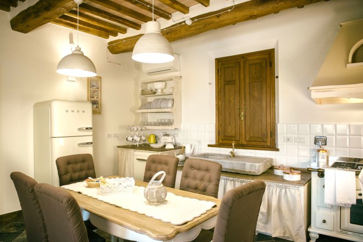 Spacious and bright kitchen featuring rustic elements and a modern Smeg refrigerator.