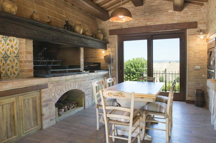 Simple interior with a fireplace and a view of the green hills, perfect for a peaceful stay.