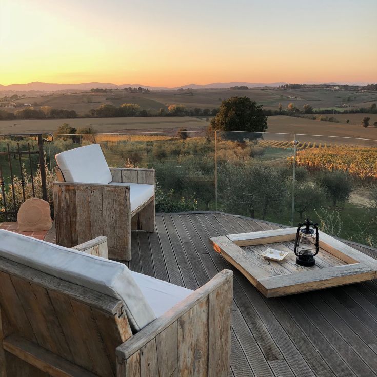 A terrace overlooking hills and vineyards, perfect for relaxation during sunset.