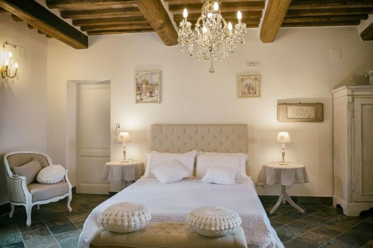 Simple bedroom with covered beds and natural light, set in a beautiful Umbrian natural context.