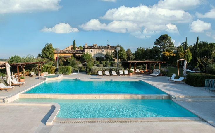 Infinity pool at Tenuta dei Mori, surrounded by greenery and olive trees.