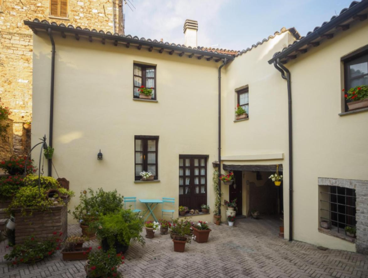 Ambiente sereno e arredato con piante varie in un cortile privato e riservato.