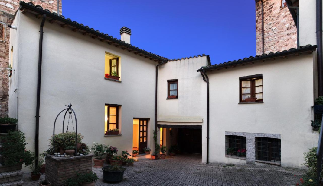 Courtyard of a villa featuring simple architectural elements and plants arranged in the patio.