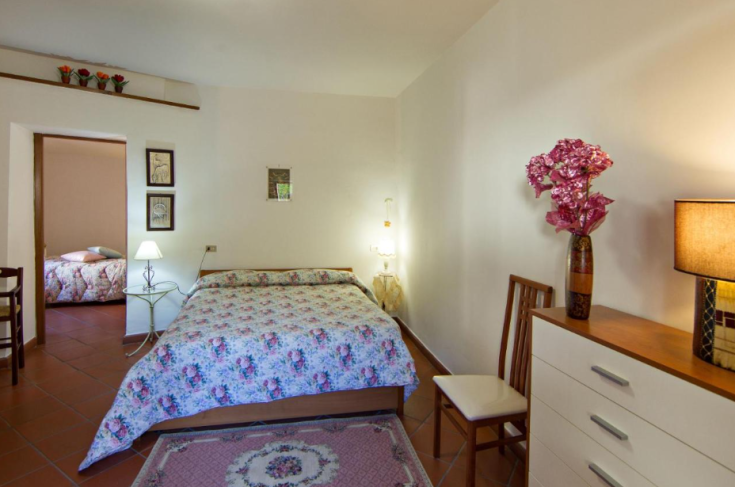 Camera luminosa con letto matrimoniale e arredamento sobrio e funzionale.