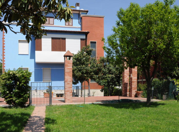 Una palazzina moderna con un ampio giardino verde.