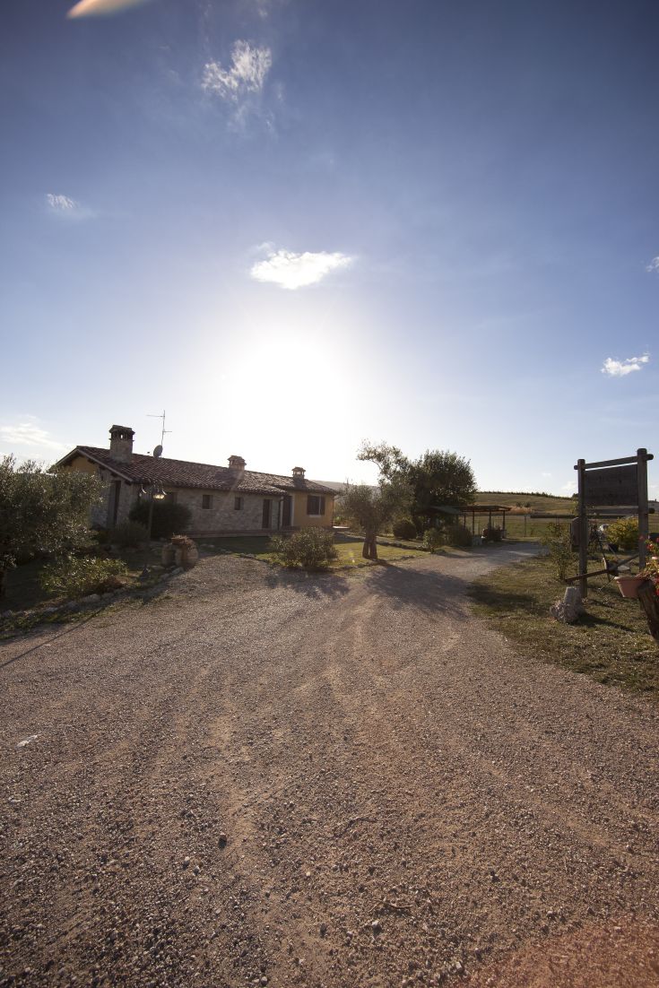 Agriturismo con appartamenti indipendenti e piscina, circondato da colline in Umbria.