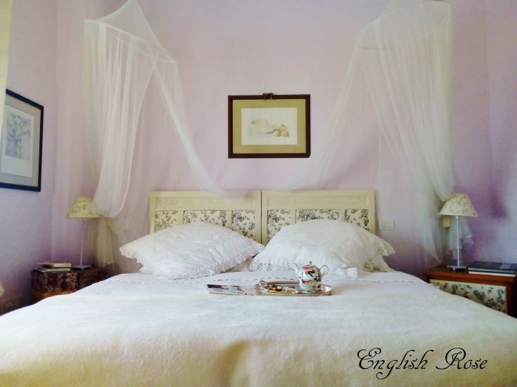 A relaxing room with a double bed and simple floral decorations.