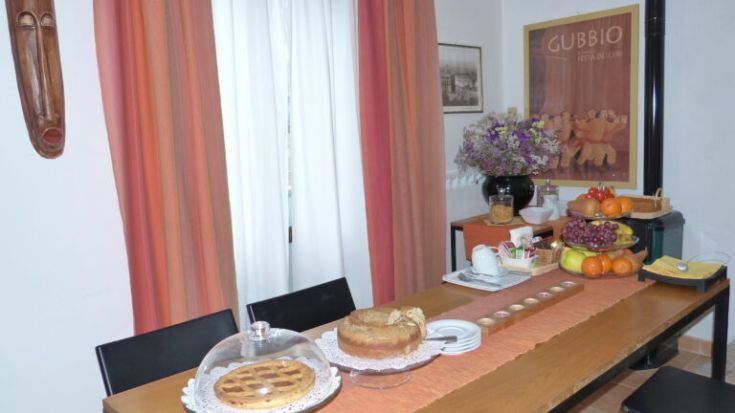 A breakfast table set with pastries and fresh fruit in a relaxed and comfortable atmosphere.