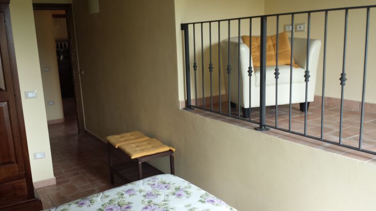 Simple interior with an armchair and bed, perfect for relaxing moments.