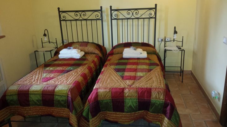 Cozy room with two single beds, featuring warm tones and simple details.