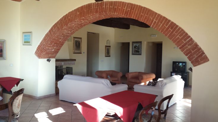 Bright and cozy interiors of a building featuring brick arches and functional furniture.