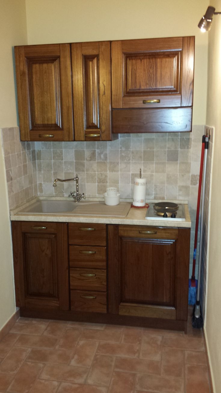 Practical wooden kitchen, well-organized with a stove and sink. Traditional furnishings in a cozy environment.