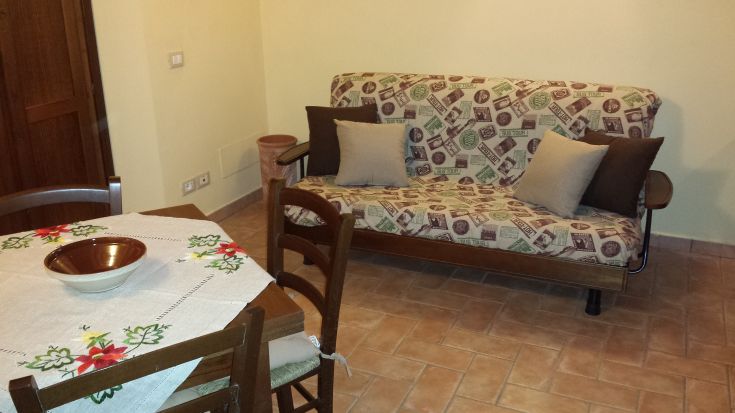 A bright living room with a cozy sofa and a dining table, perfect for spending time together.