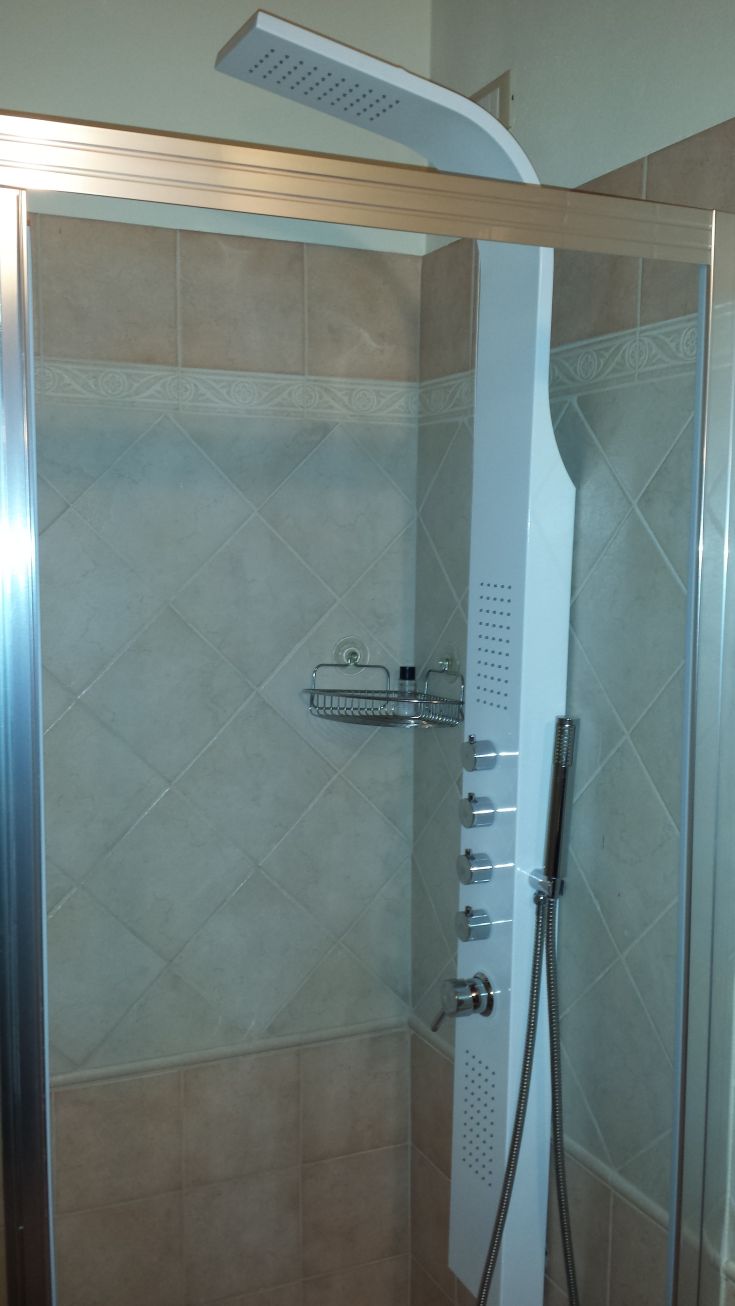 Modern shower with ceramic base, featuring functional fixtures for a relaxing atmosphere.