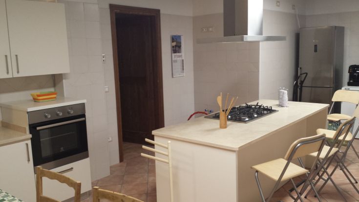 Modern and functional kitchen featuring a central island and seating area. Discreet and comfortable furnishings.